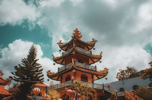 Ngôi chùa nhiều tầng mái cong đỏ nâu dưới nền trời xanh mây trắng ở Huế
