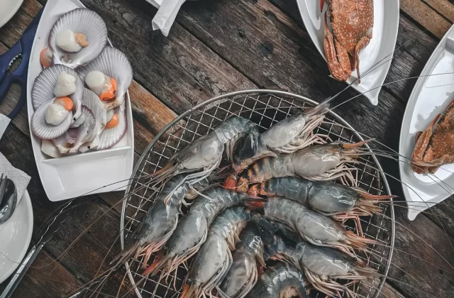 Tôm nướng, sò và cua hải sản trên bàn gỗ