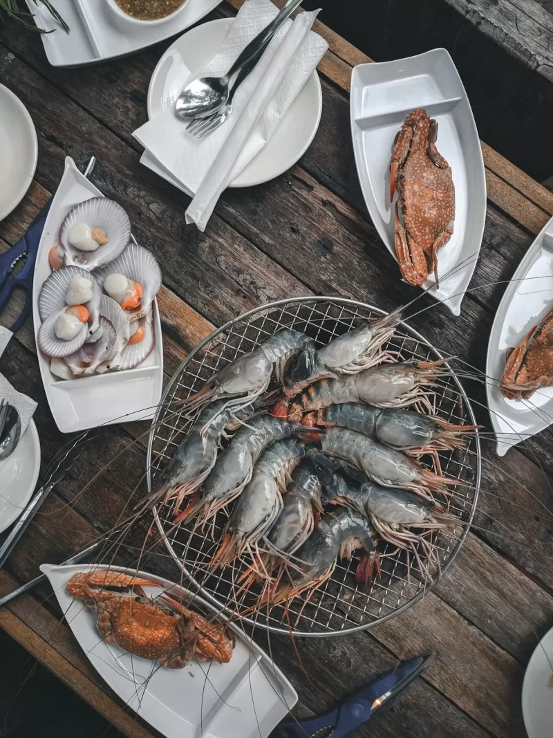 Tôm nướng, sò và cua hải sản trên bàn gỗ