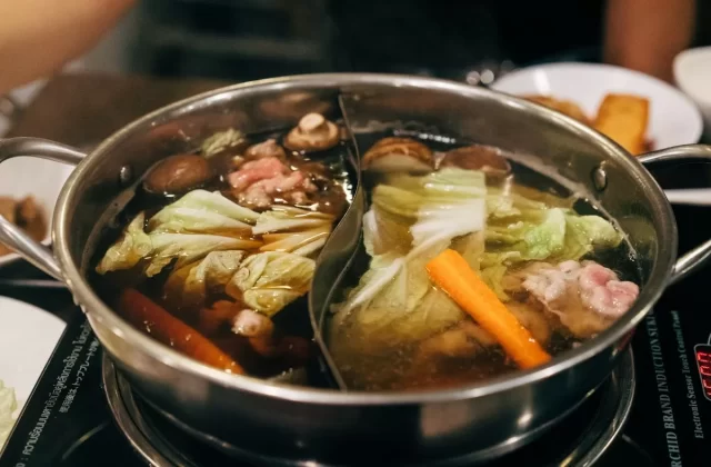 Nồi lẩu hai ngăn với rau cải, nấm và thịt