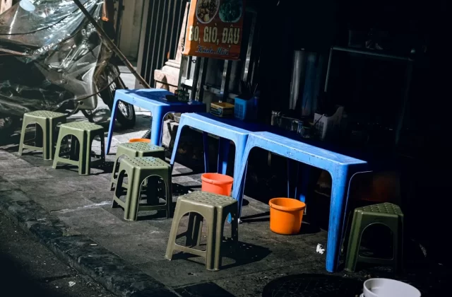 Bàn ghế nhựa thấp bên vỉa hè quán ăn đường phố