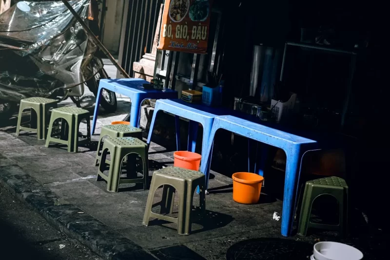 Bàn ghế nhựa thấp bên vỉa hè quán ăn đường phố