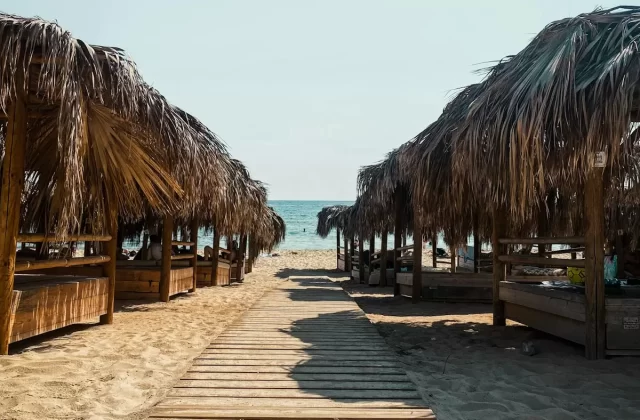 Lối đi ván gỗ dẫn ra bãi biển giữa các chòi mái lá