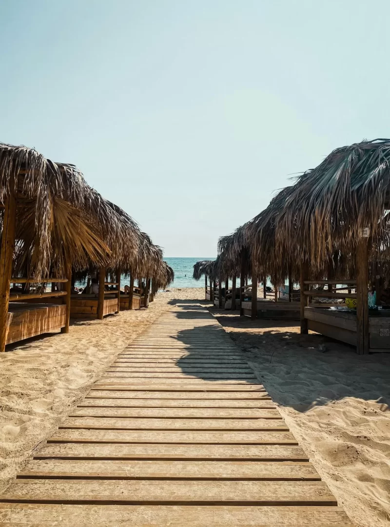 Lối đi ván gỗ dẫn ra bãi biển giữa các chòi mái lá