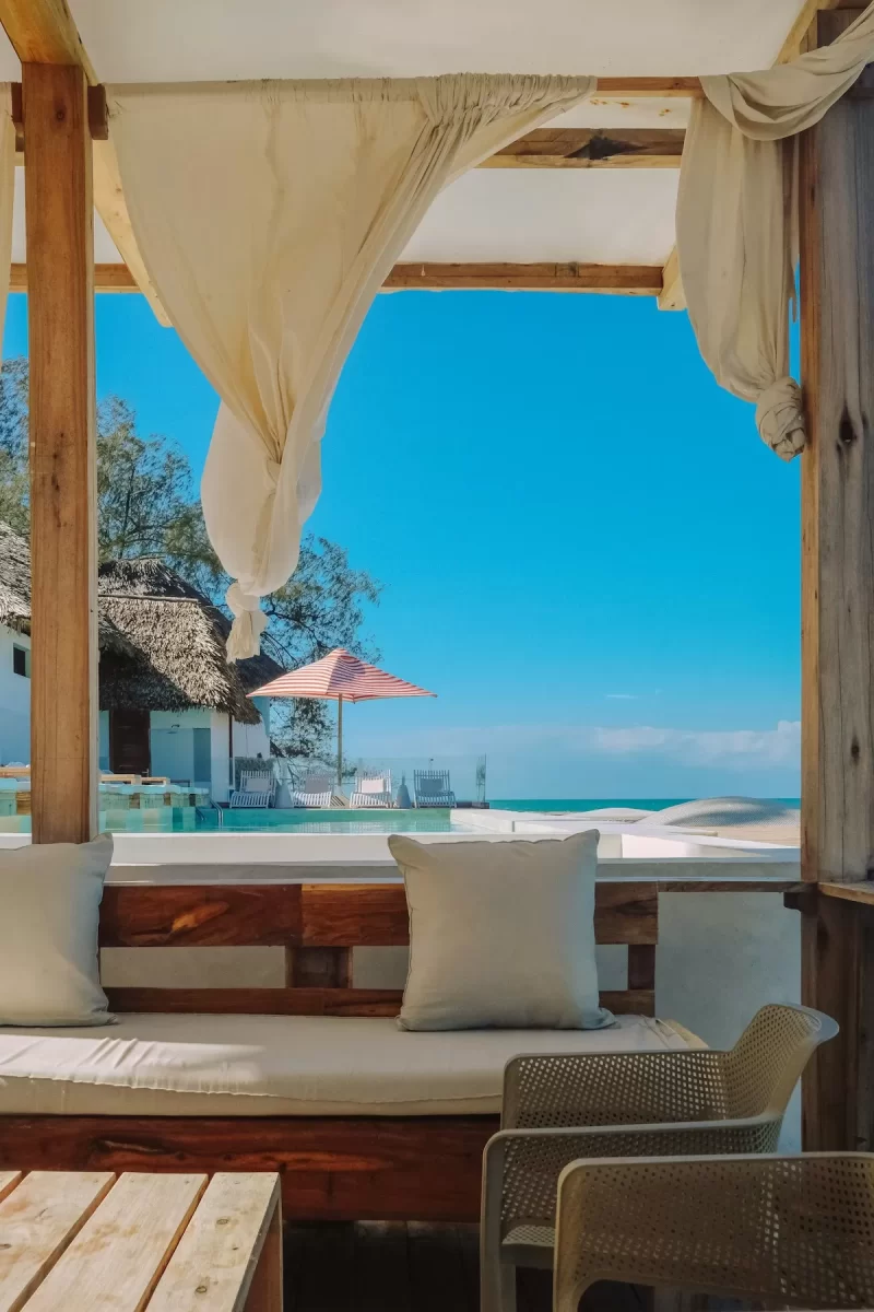 Phòng nghỉ mở ra hồ bơi và biển xanh với rèm trắng bay