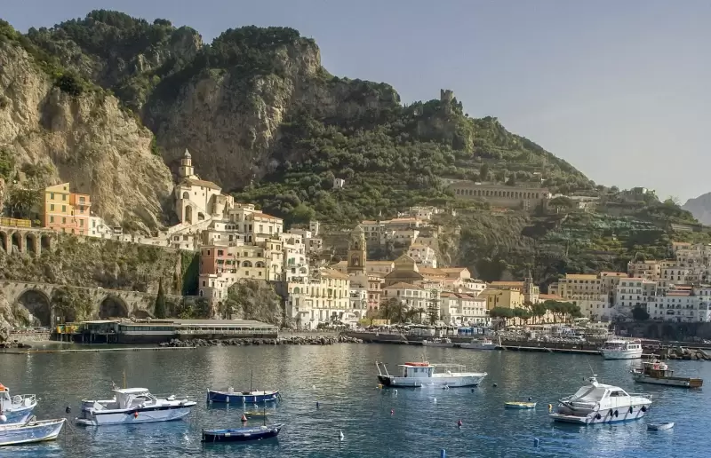 Du thuyền trắng trên vùng biển xanh dưới vách núi bờ biển Amalfi