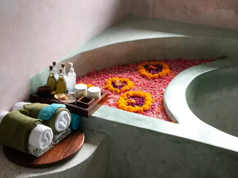 Bồn tắm spa rải cánh hoa cùng khăn và dầu thơm