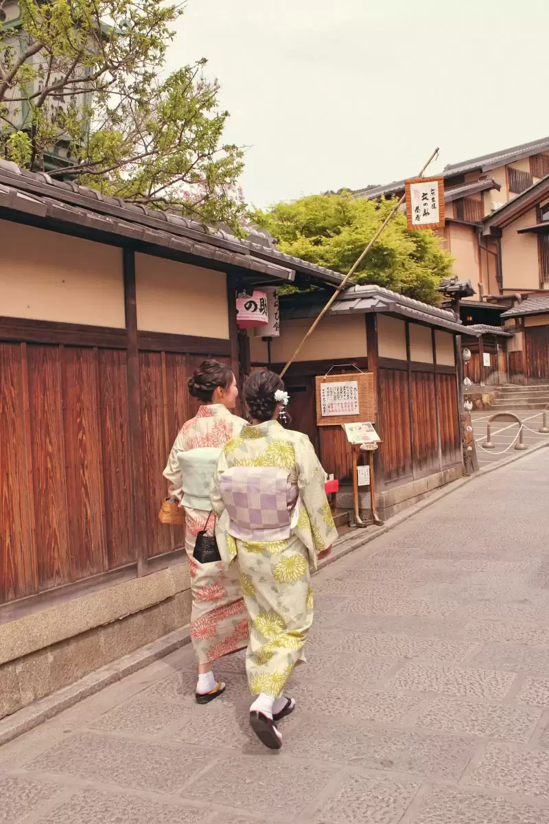 Hai phụ nữ mặc kimono đi trên con phố gỗ cổ ở Gion, Kyoto