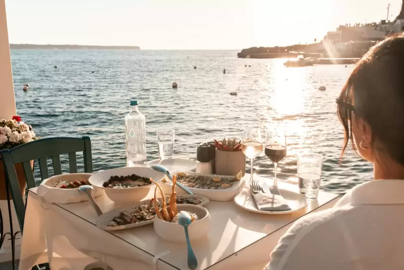 Bàn tối bên hiên nhìn ra biển lúc hoàng hôn ở Fira, Santorini