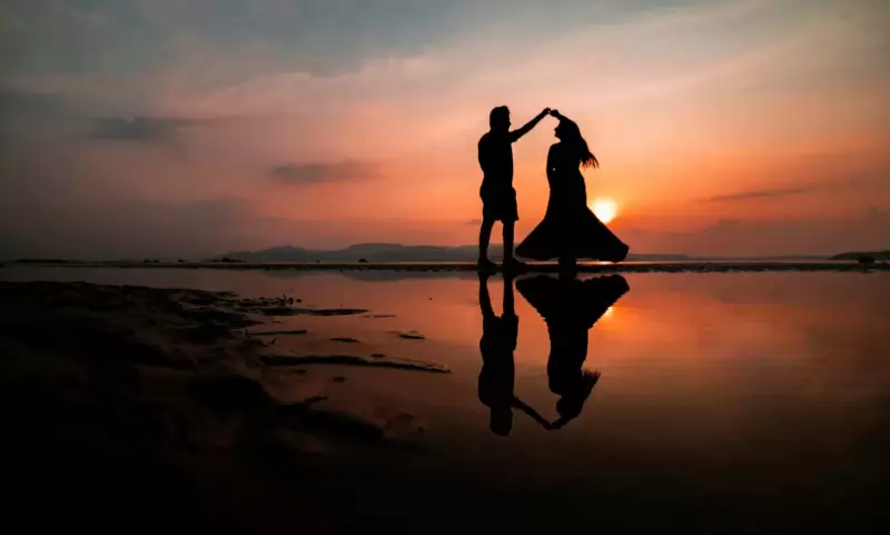 Cặp đôi khiêu vũ trên bãi biển lúc hoàng hôn