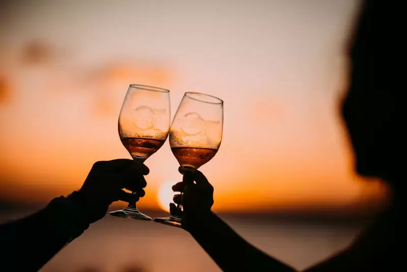 Hai ly vang nâng lên trước hoàng hôn