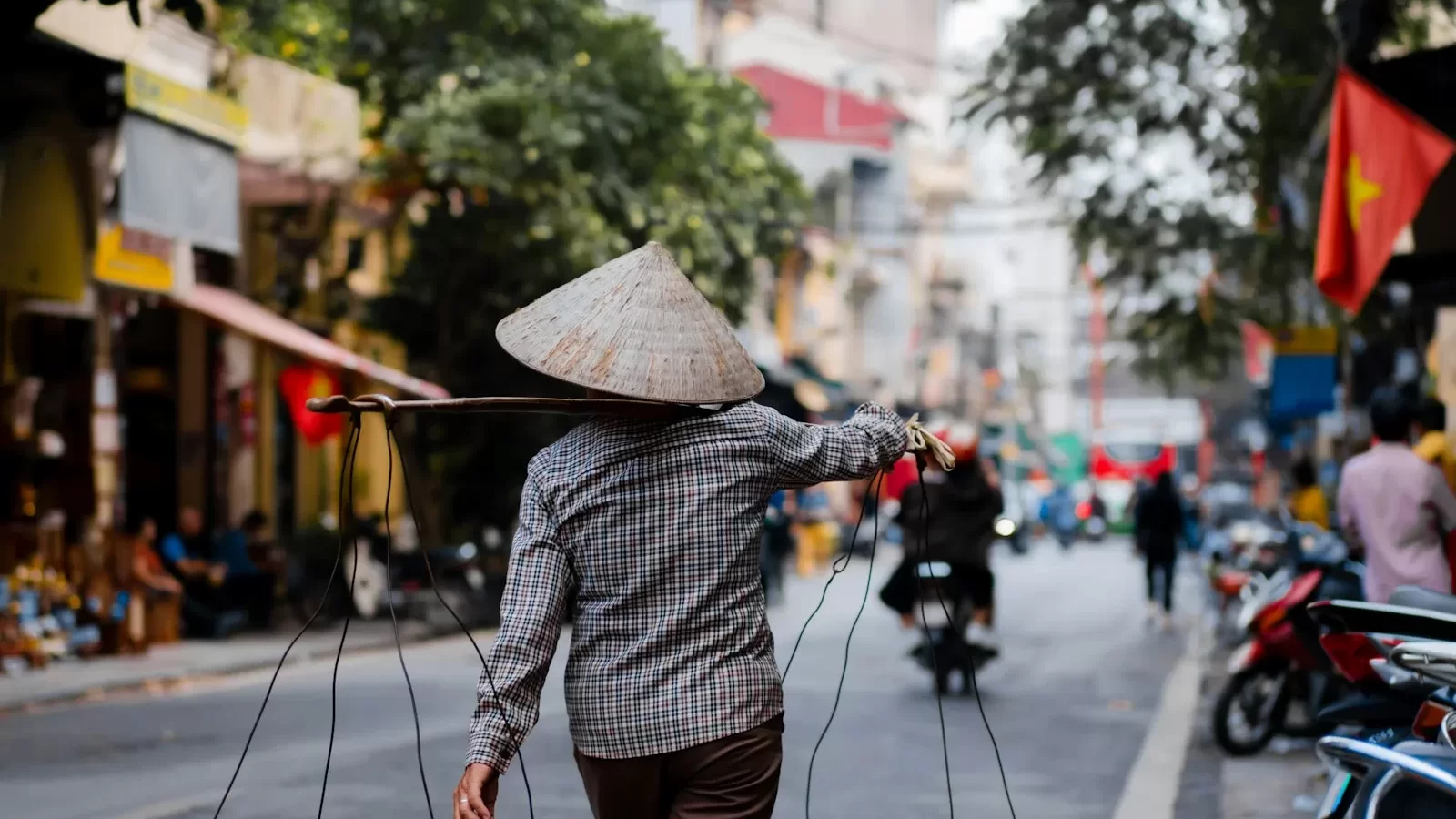 Người bán hàng rong đội nón lá gánh quang gánh trên phố Hà Nội