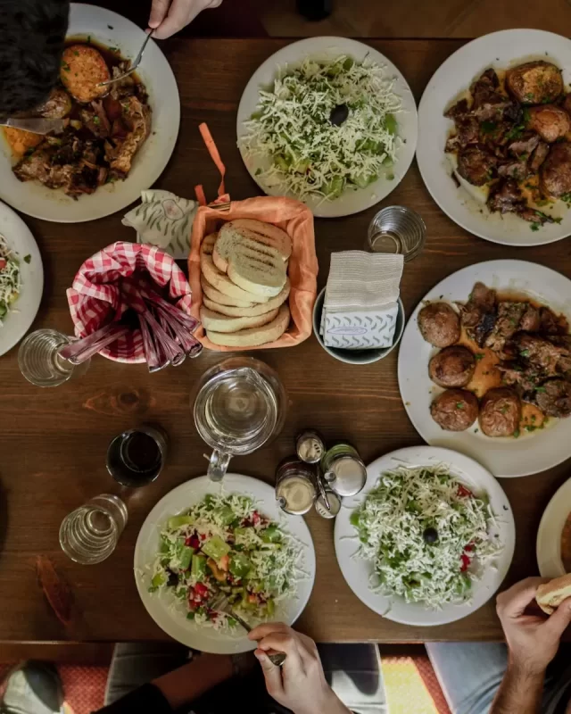 Bàn tiệc nhìn từ trên xuống với nhiều đĩa thức ăn và salad