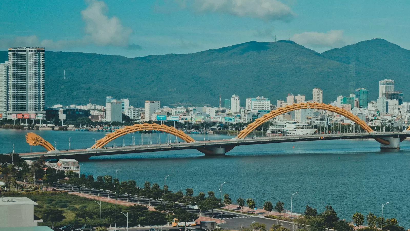 Cầu Rồng vắt qua sông Hàn, phía sau là thành phố Đà Nẵng và núi