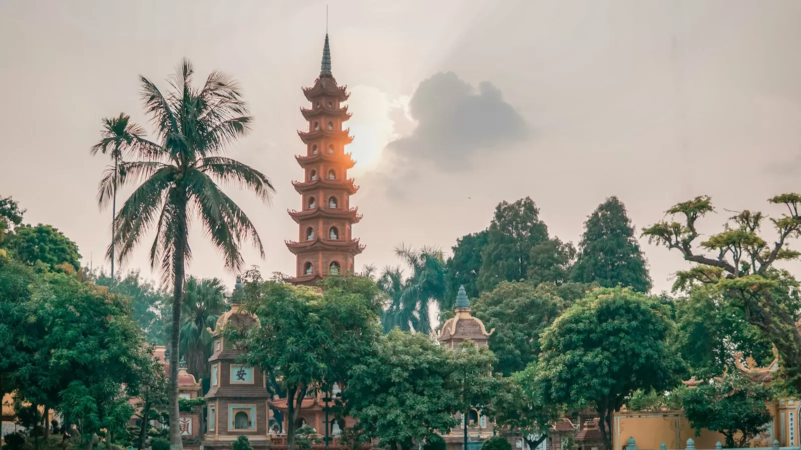 Ngọn tháp chùa nhiều tầng giữa hàng cây xanh dưới nắng chiều Hà Nội