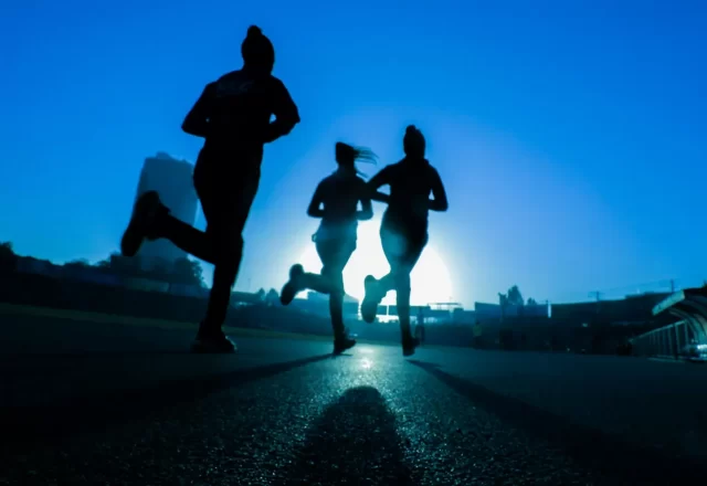 Ba vận động viên chạy trên đường nền trời xanh lúc bình minh
