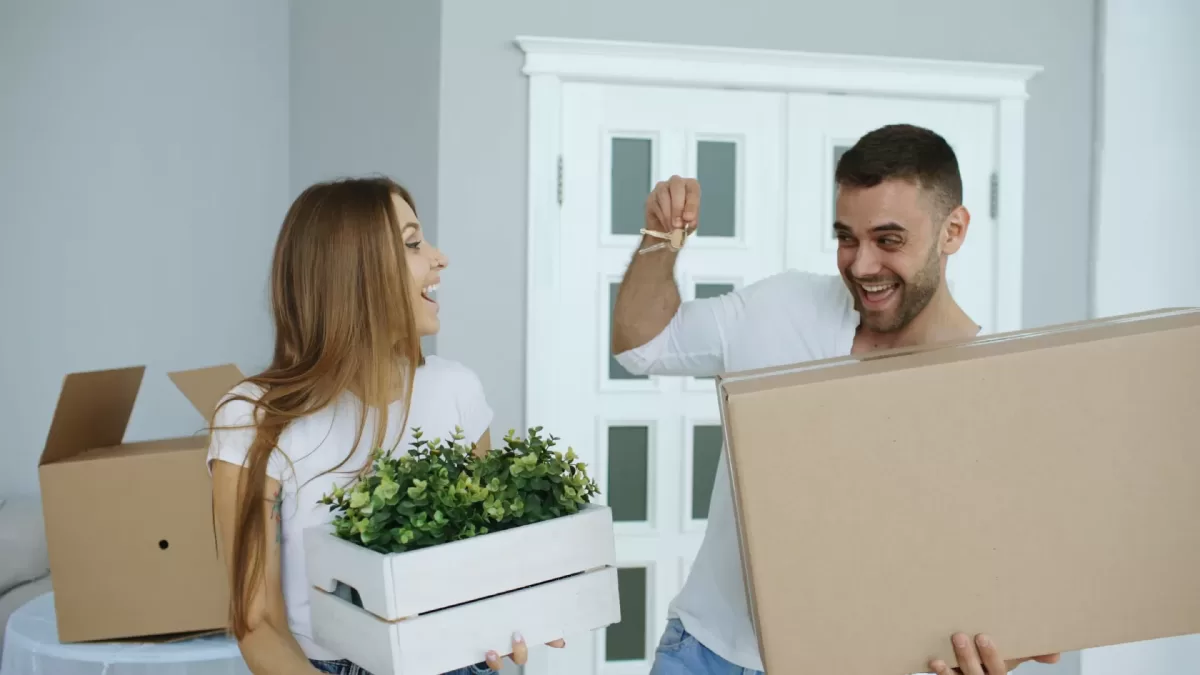 Cặp vợ chồng trẻ vui vẻ chuyển vào căn hộ mới