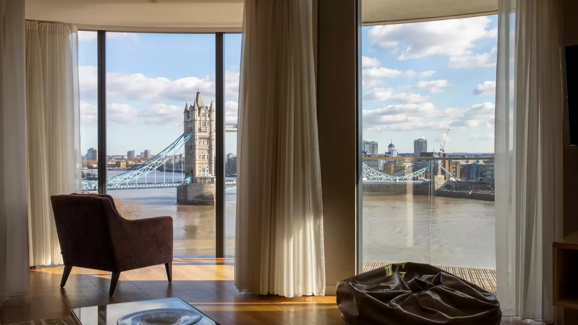 Phòng khách penthouse rộng với cửa kính lớn nhìn ra thành phố