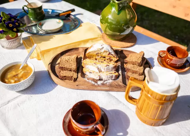 Bàn ăn ngoài trời với bánh mì, súp và đồ uống