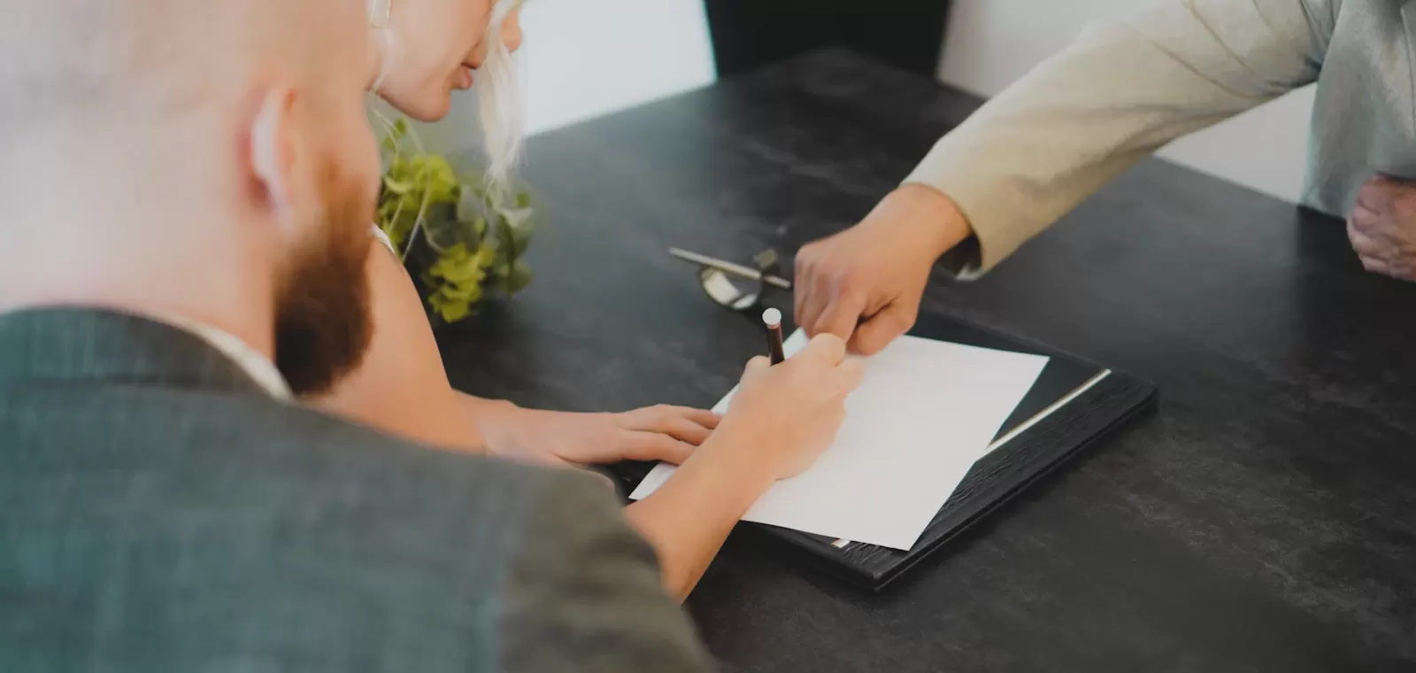 Cặp vợ chồng ký giấy tờ tại bàn làm việc