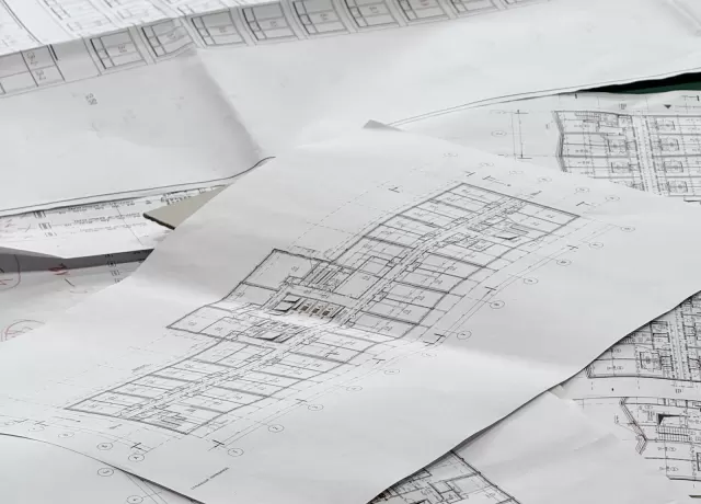Các bản vẽ kiến trúc trải trên mặt bàn