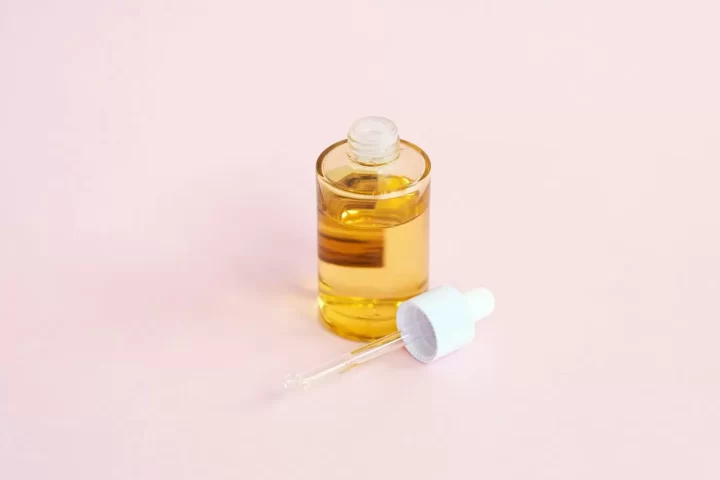 Chai serum nhỏ giọt trên nền hồng