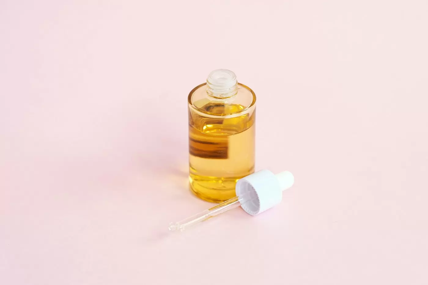 Chai serum nhỏ giọt trên nền hồng