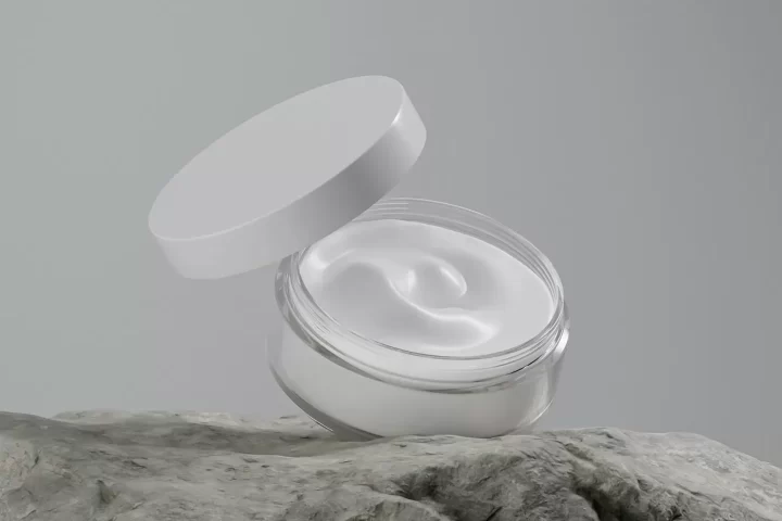 Hũ kem dưỡng mở nắp đặt trên phiến đá