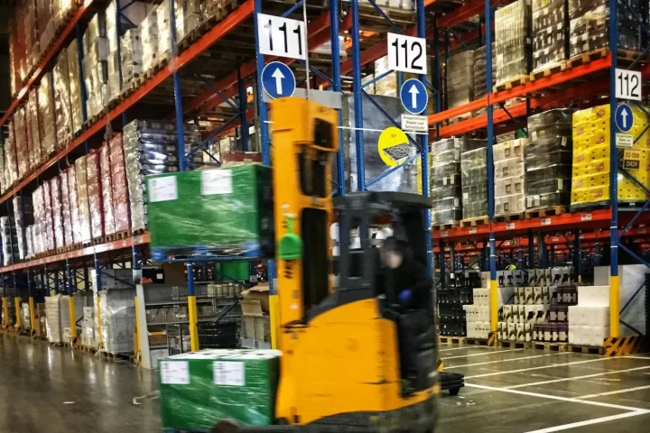 Xe nâng di chuyển giữa các kệ pallet trong kho thành phẩm