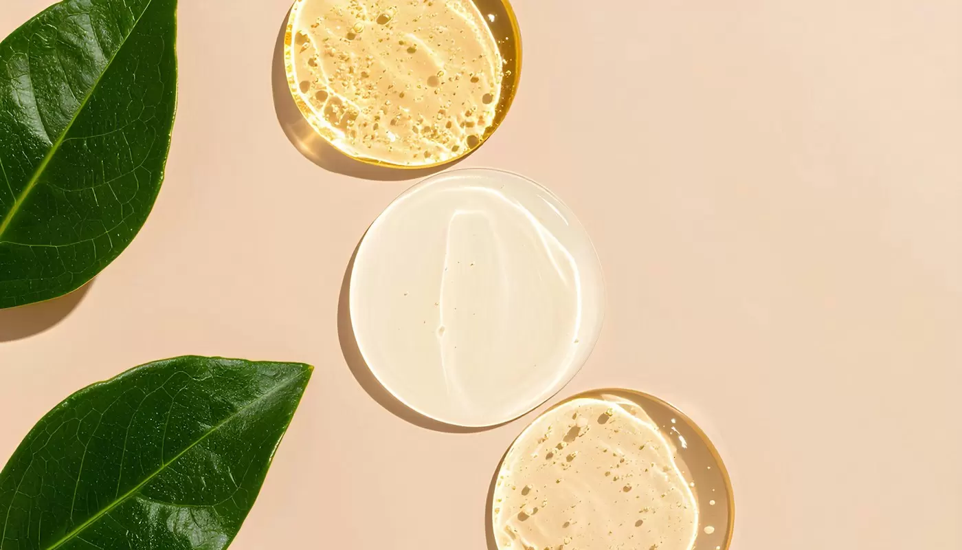 Mẫu kem và serum bên lá xanh trên nền be