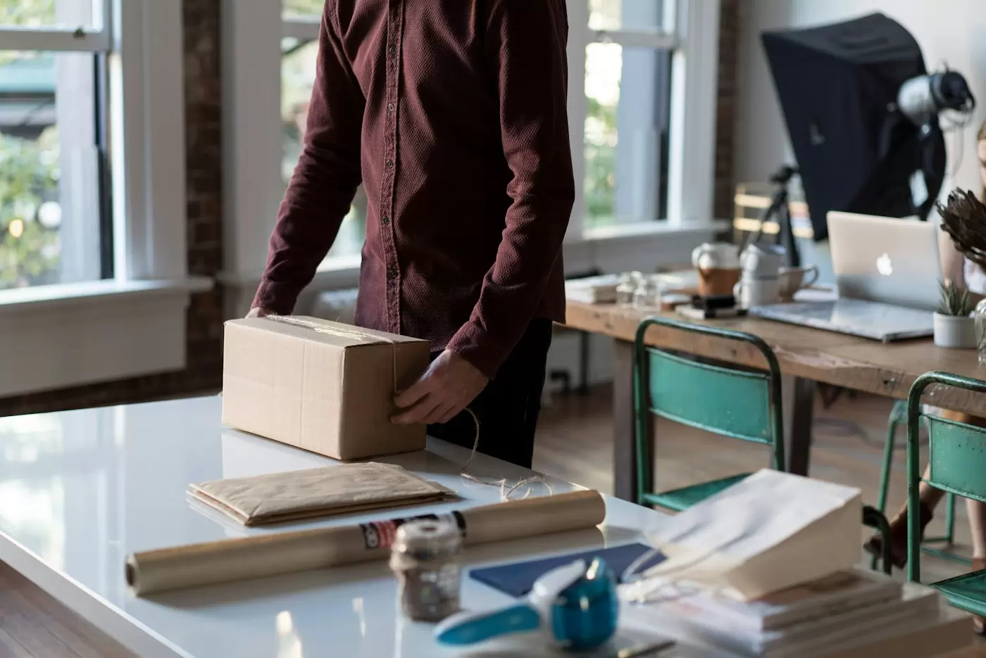 Người đóng gói thùng carton trên bàn làm việc