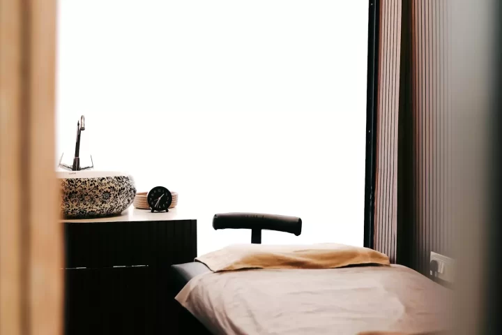 Giường massage phủ khăn be trong phòng spa