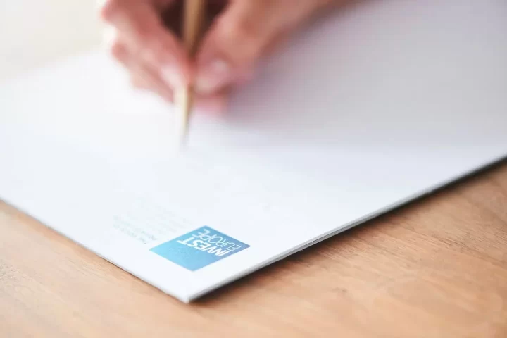 Bàn tay viết trên tờ giấy trắng