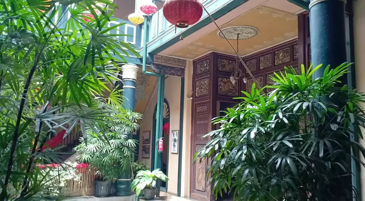 Ban công và hiên nhà trồng nhiều chậu cây, treo đèn lồng nhỏ ở homestay Hẻm Cau Lầu gần phố cổ Hội An