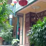 Ban công và hiên nhà trồng nhiều chậu cây, treo đèn lồng nhỏ ở homestay Hẻm Cau Lầu gần phố cổ Hội An