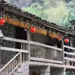 Ngôi nhà gỗ vùng cao treo bắp ngô và đèn lồng đỏ dưới hiên, gợi không khí nhà trình tường ở Đồng Văn, Hà Giang