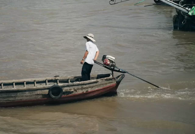 Người chèo xuồng trên sông nước đục phù sa miền Tây