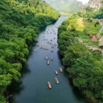 Dòng sông uốn quanh núi đá vôi và rừng xanh Ninh Bình nhìn từ trên cao