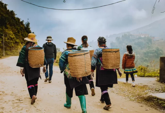 Đoàn trekking cùng người dẫn đường bản địa gùi sọt đi trên đường núi Sa Pa