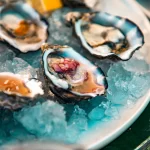 Hàu sữa tươi mở vỏ trên đá lạnh có lát chanh