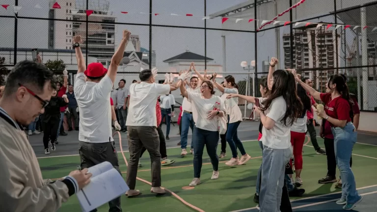 Đồng đội giơ tay ăn mừng sau chặng chơi team building ngoài trời