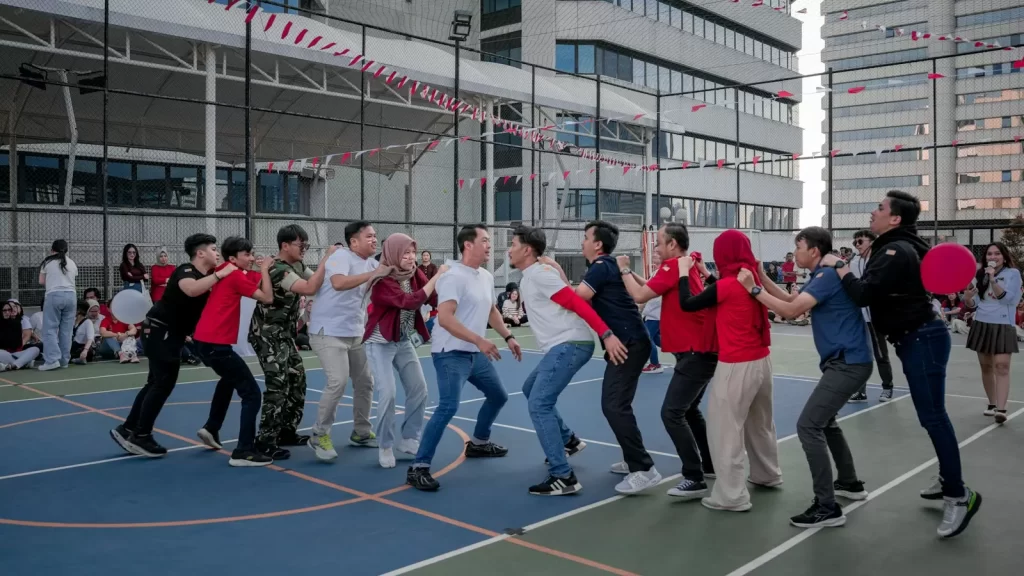 Nhóm người chơi trò kéo co trên bãi cỏ trong chương trình team building