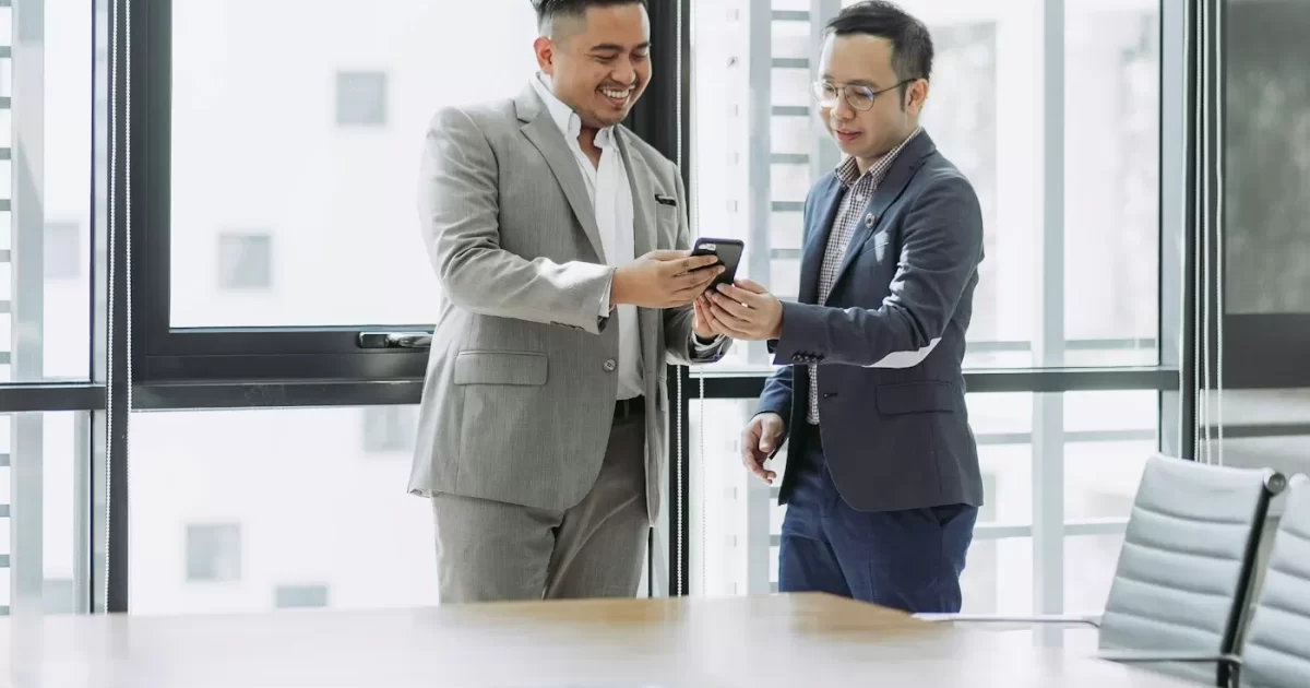 Hai người trao đổi trong phòng họp kính