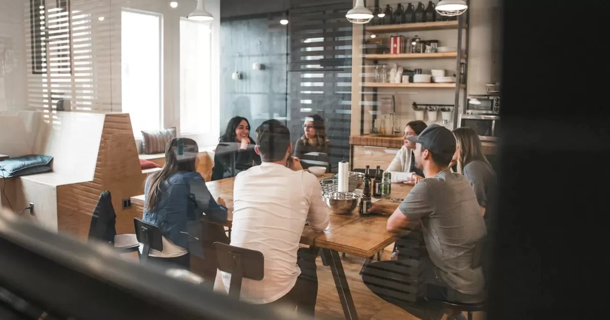 Nhóm nhân sự trao đổi quanh bàn họp gỗ