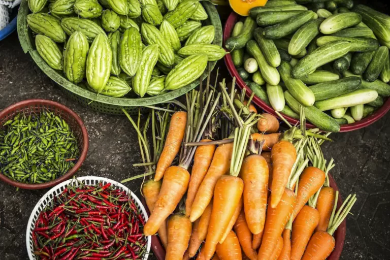 Rau củ và ớt tươi trên bàn, cà rốt, mướp đắng và ớt đỏ