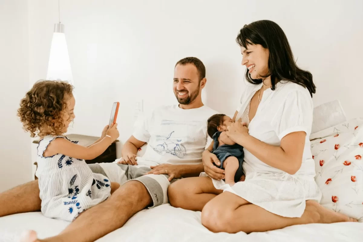 Gia đình ba người ngồi trên giường, hôn nhân gia đình và nuôi con