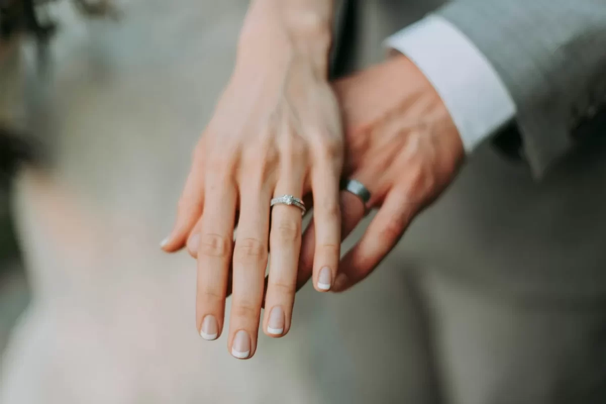 Hai bàn tay vợ chồng đeo nhẫn cưới đặt cạnh nhau
