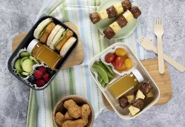 Hộp cơm của bé với bánh sandwich, xiên bánh, trái cây và nước ép, thành phần rõ ràng