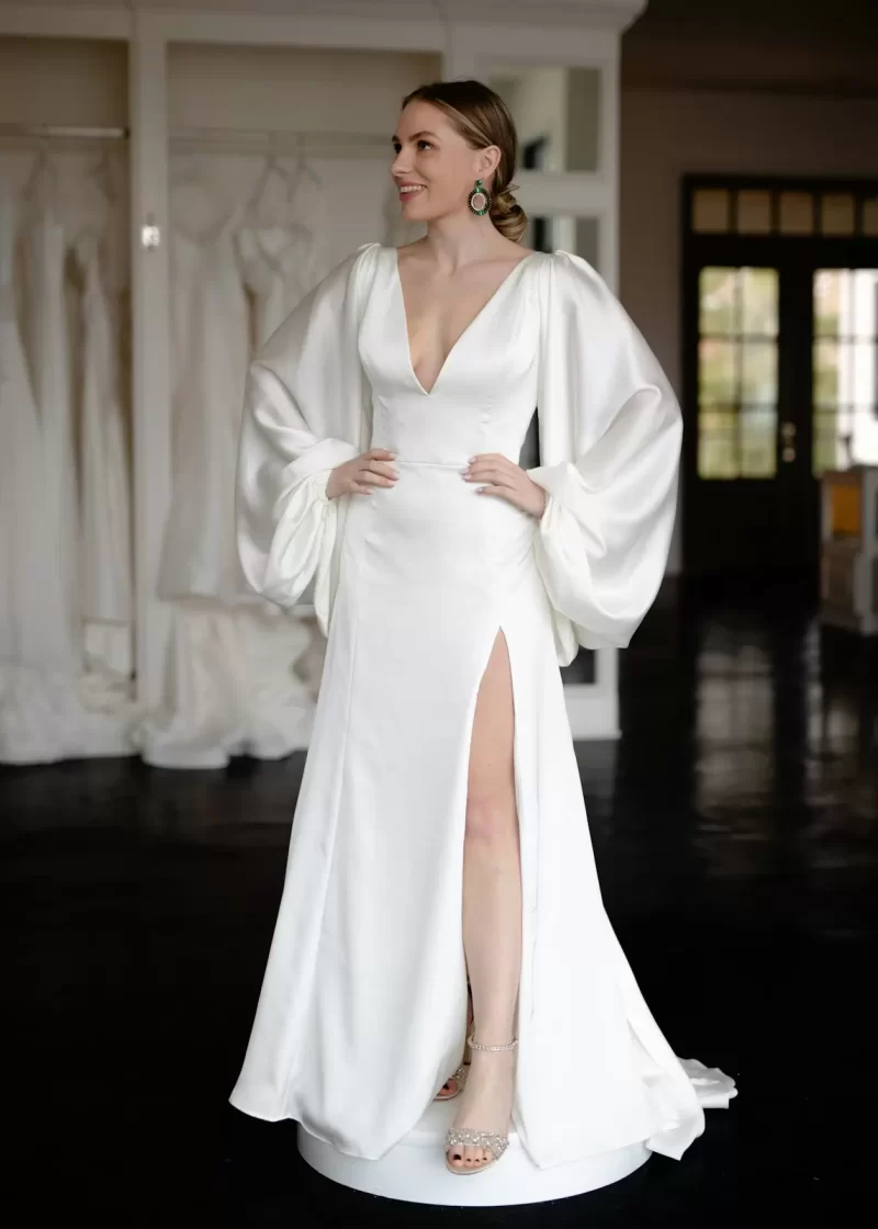 Cô dâu mặc váy satin trắng tối giản tay bồng và xẻ tà trong phòng thử váy