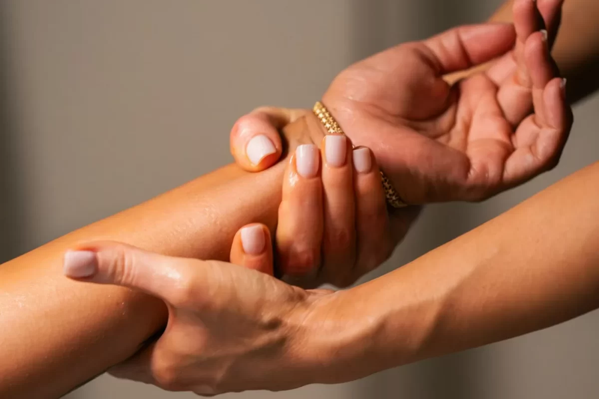 Hai bàn tay xoa bóp nhẹ cổ tay và cẳng tay, sắc ấm dịu